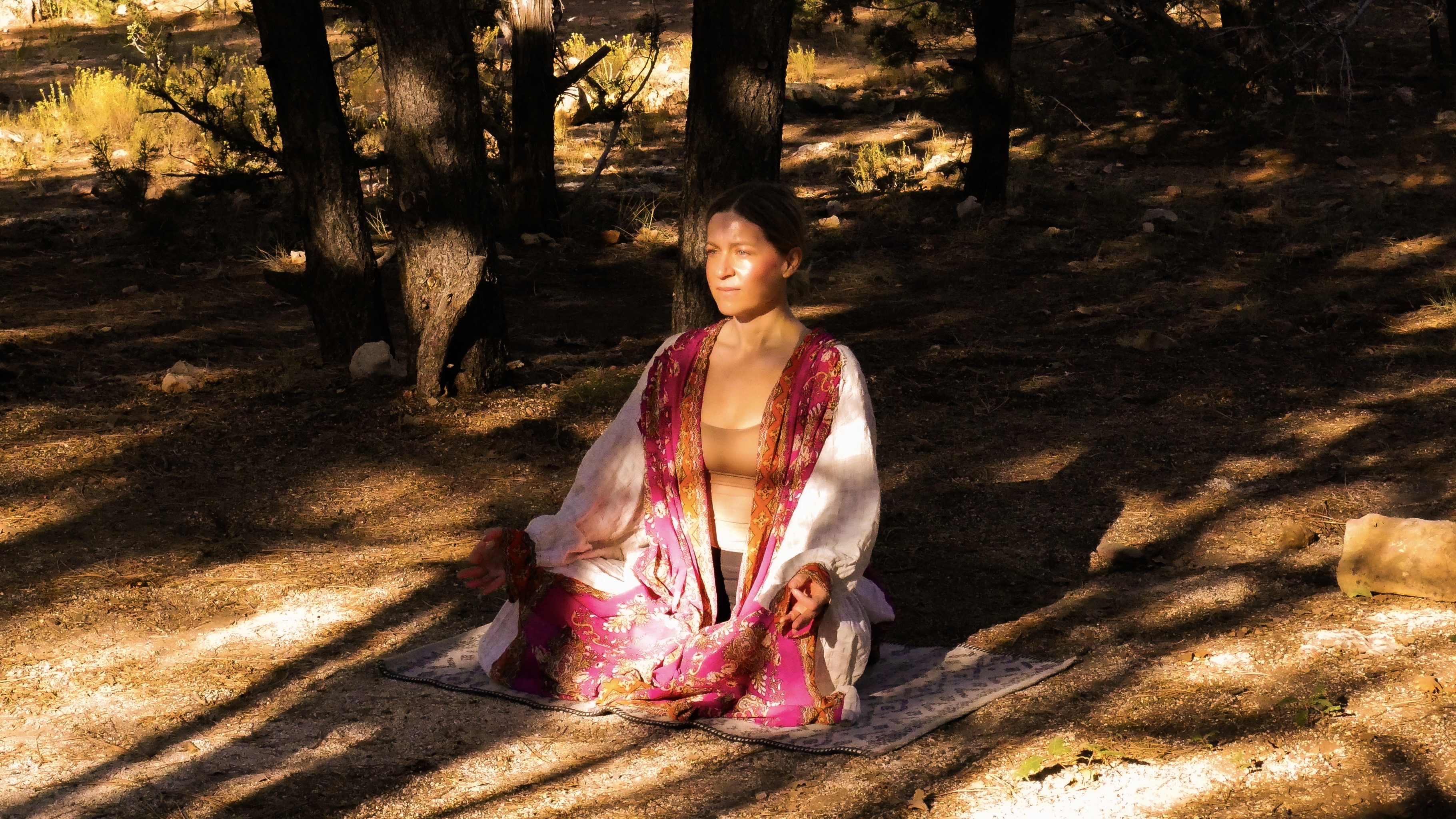 Heather practicing yin yoga outdoors in dappled light